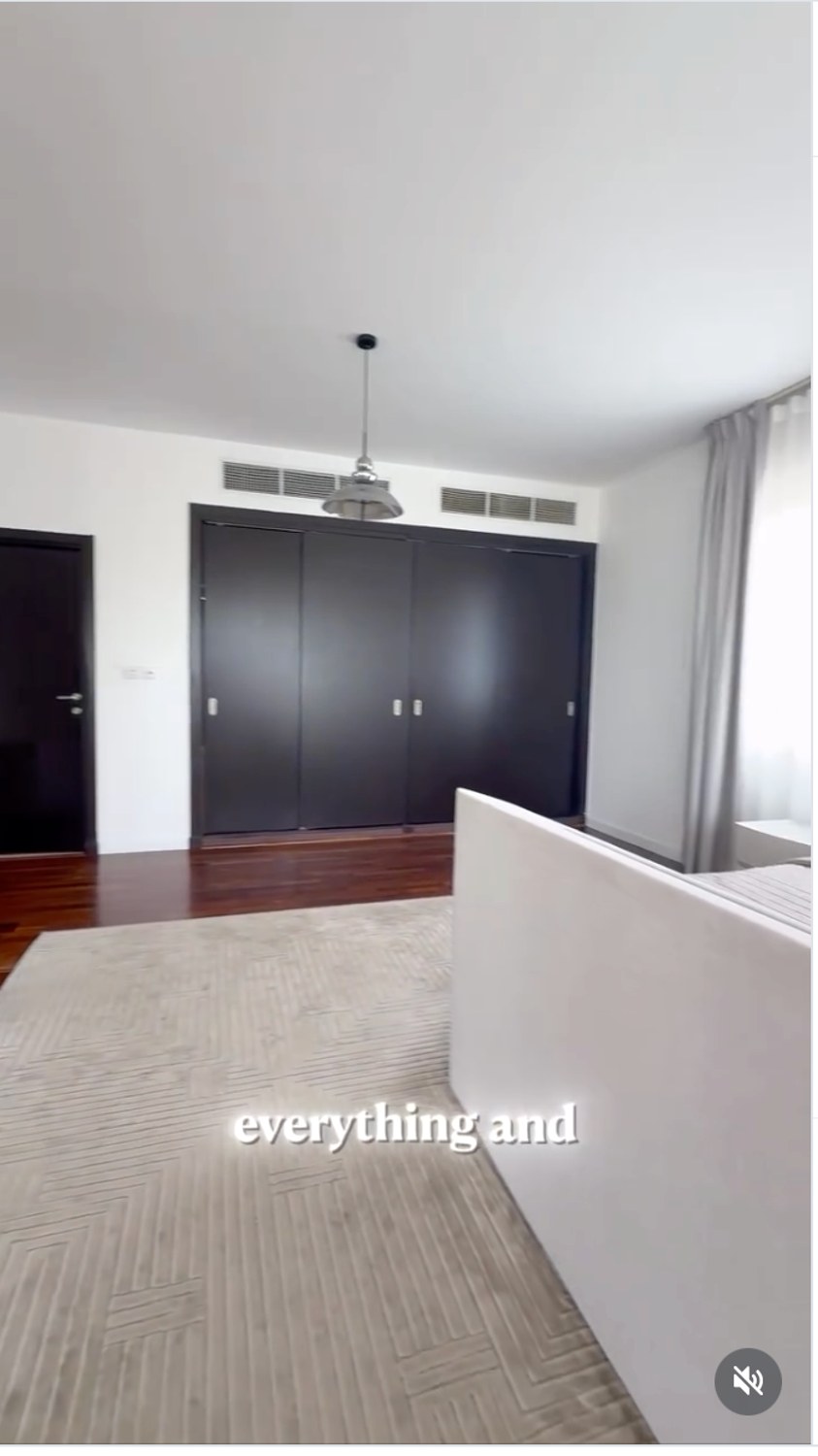 Finished bedroom with neutral bedding and custom storage